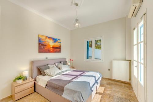a bedroom with a bed and a painting on the wall at Syros Private House with superb sea view in Kinion