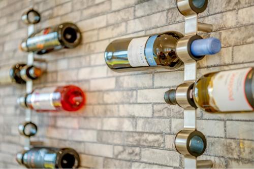 a wall of wine bottles on a brick wall at Syros Private House with superb sea view in Kinion