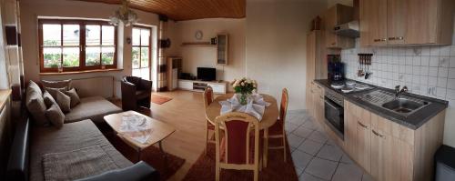 cocina y sala de estar con mesa y sofá en Ferienwohnungen Kasparbauer, en Regen
