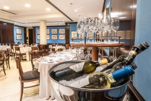 un restaurante con botellas de vino en un cubo en Caesar's Hotel en Cagliari