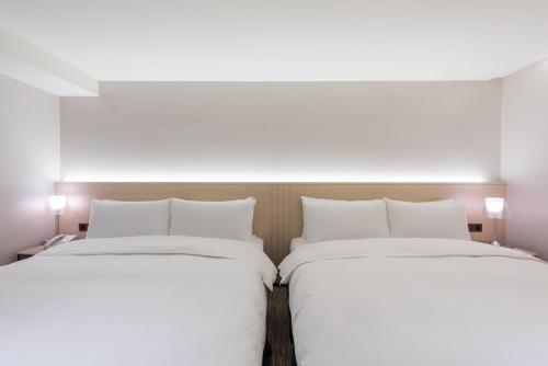 two beds sitting next to each other in a room at K Hotel Taipei Chang-An in Taipei