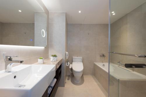 a bathroom with a sink and a toilet and a tub at K Hotel Taipei Chang-An in Taipei