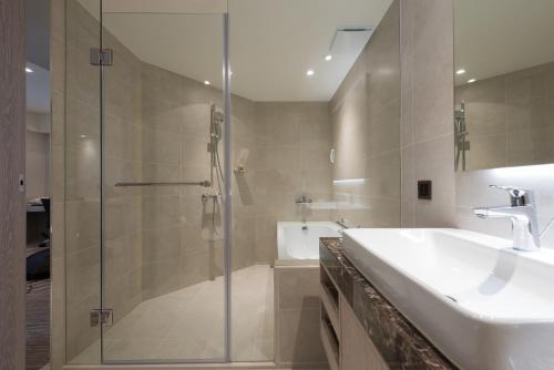 a bathroom with a shower and a sink and a tub at K Hotel Taipei Chang-An in Taipei