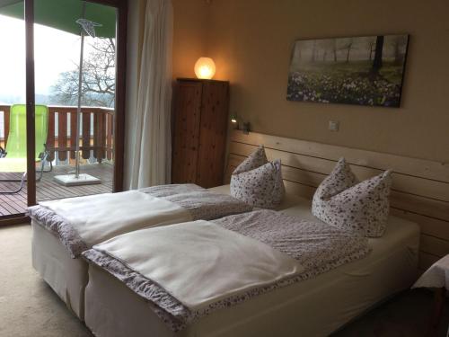a bedroom with a bed with white sheets and pillows at Ferienwohnung-BergIdylle-bei-Hotel-BERGHOF in Lichtenhain