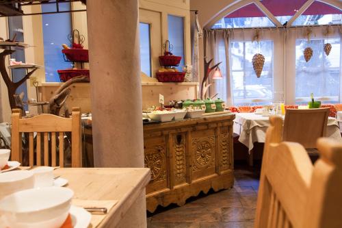 a dining room with a table and two tables and chairs at Am Dorfplatz Suites - Adults friendly in Sankt Anton am Arlberg