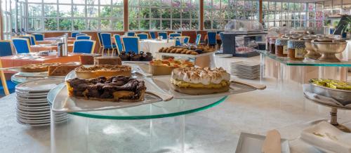 a table filled with different types of cakes on plates at Caesar's Hotel in Cagliari