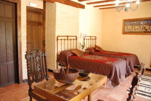 a bedroom with two beds and a table and a table sidx sidx sidx at La Casa de Alberto in Ribas de Tereso