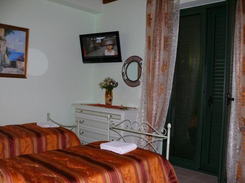 a bedroom with two beds and a dresser and a mirror at B&B La Vecchia Stazione in Gioiosa Ionica