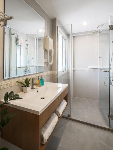 a bathroom with a large sink and a shower at Ton Aor Place Hotel in Bangkok