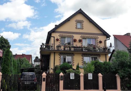 een geel huis met een hek ervoor bij Noclegi u Eli in Świnoujście