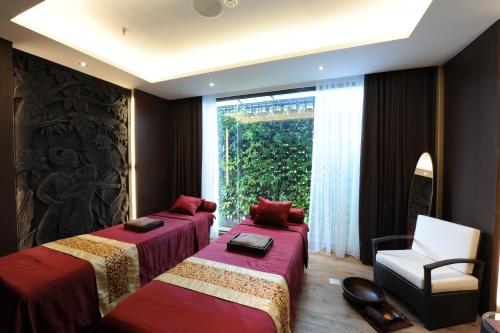 a room with two beds and a chair and a window at Hotel Borobudur Jakarta in Jakarta