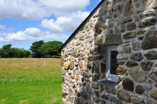 a window on the side of a stone building at The Barn at Cae Bach in Gwalchmai