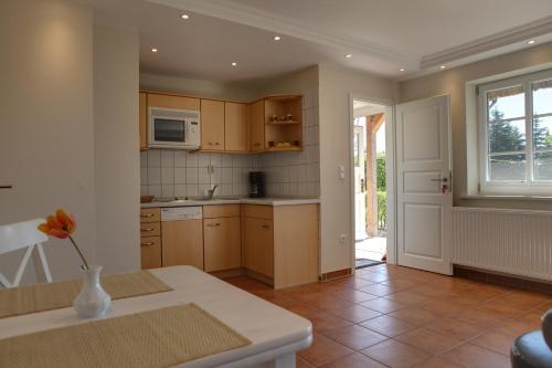 a kitchen with wooden cabinets and a vase with a flower at Haus Sonnenblume in Lohme