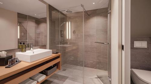 ein Bad mit einem Waschbecken und einer Dusche in der Unterkunft Hotel the YARD in Berlin