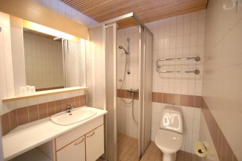 ein Bad mit einem Waschbecken, einem WC und einer Dusche in der Unterkunft Tanhuvaara Sport Resort in Savonlinna
