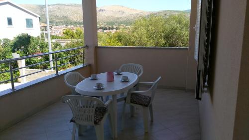 una mesa blanca y sillas en un balcón con vistas en Apartments Marija, en Trogir