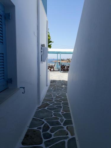 a hallway with a stone walkway leading to the beach at Paros Carmel studio-apartment in Logaras