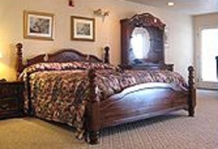 um quarto com uma cama de madeira com uma estrutura de madeira em Fairview Beachfront Inn em Mackinaw City