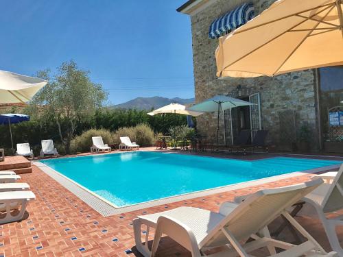 a swimming pool with chairs and umbrellas next to a building at Casa Vacanze Il Cenito in Castellabate