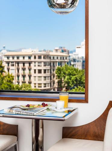 a table with a plate of food and a window at Palacio Avenida in Palma de Mallorca
