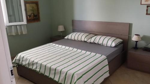 a bedroom with a bed with a wooden headboard at Lacona Casa Franca in Lacona