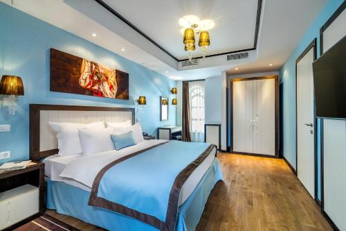 a bedroom with a large bed with blue walls at Epoque Hotel - Relais & Chateaux in Bucharest
