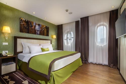 a bedroom with a large bed and a television at Epoque Hotel - Relais & Chateaux in Bucharest