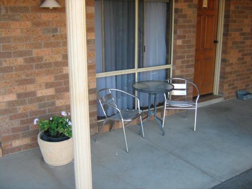 a patio with two chairs and a table on a porch at Highway Inn Motel in Hay