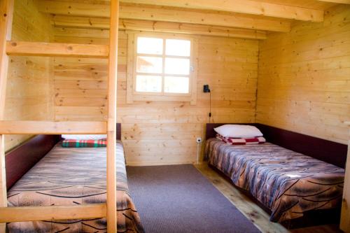 كامبينغ مانيسالو في تويلا: غرفة نوم مع سريرين بطابقين في كابينة خشب