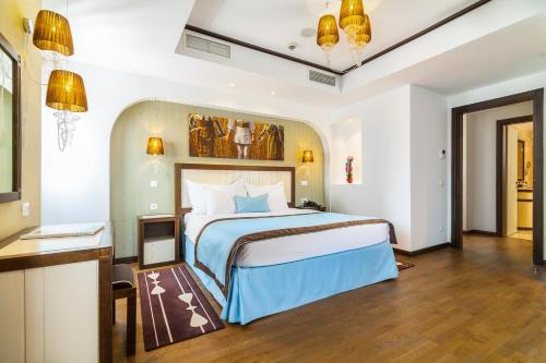 um quarto de hotel com uma cama grande e uma secretária em Epoque Hotel - Relais & Chateaux em Bucareste