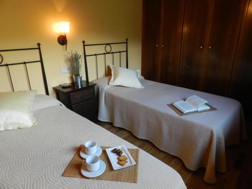 a hotel room with two beds and a tray with books at Apartaments El Tossalet in Bonansa