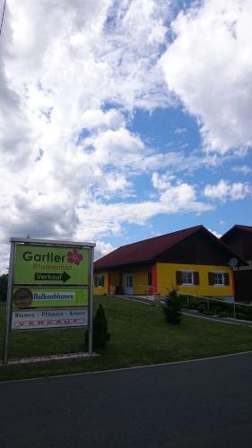 a yellow house with a sign in front of it at Gartler's Ferienhaus in Weitersfeld an der Mur