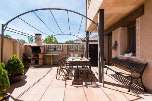 patio con mesa y sillas en el balcón en El Descanso de los Lares, en Miguel-Ibáñez