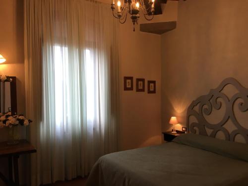 a bedroom with a bed and a window with curtains at Agrisalotto in Cortona
