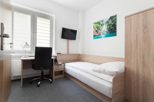 1 dormitorio con cama, escritorio y ordenador en Dom Studenta Nr 1 ANS w Koninie, en Konin