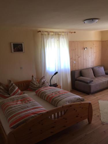 a bedroom with a large bed and a couch at Pension Höggerhof in Nova Ponente