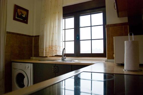 a kitchen with a sink and a washing machine at Casas Rurales Campolibre in Masegoso