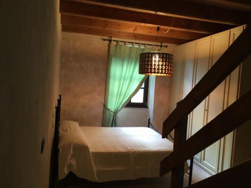 a bedroom with a bed and a window with a chandelier at La Columbera in Trento