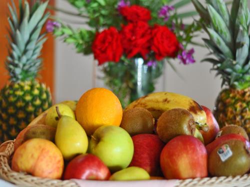 a bowl of fruit on a table with flowers at Grand Hotel Palladium Santa Eulalia del Río in Santa Eularia des Riu