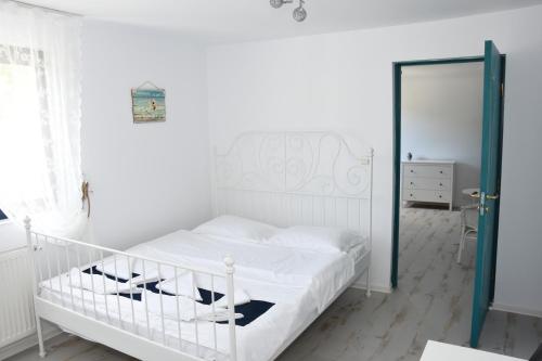 a white bed in a white bedroom with a door at Vila Selina in Eşelniţa