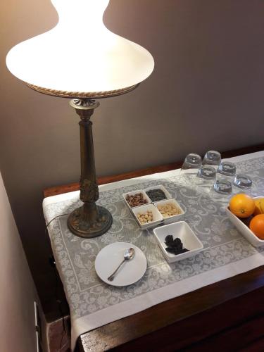 a table with a lamp and a plate of food on it at Novecento in Anagni