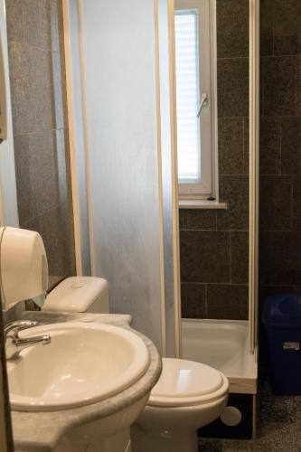 a bathroom with a sink and a toilet and a window at Apartments Japuncic in Karlobag