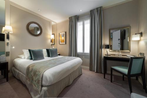 a hotel room with a bed and a desk and a mirror at Best Western Plus Hotel Sydney Opera in Paris