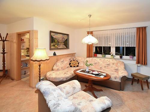 un soggiorno con divano e tavolo di Apartment with views of the Ore Mountains a Oelsnitz