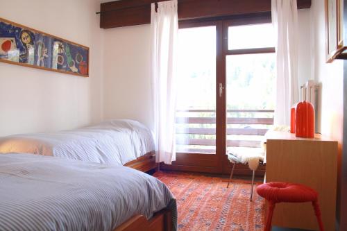 um quarto com 2 camas e uma porta de vidro deslizante em Stylish & Cozy, Préfleuri em Crans-Montana
