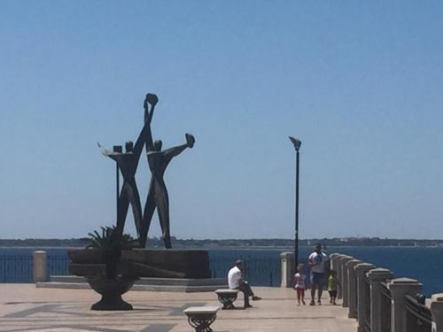 a group of people standing around a statue next to the water at Casa della Nonna Pasqua in Taranto
