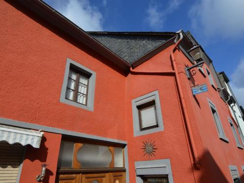 a red building with a clock on the side of it at Charming Holiday Home in Neumagen Dhron in Neumagen-Dhron