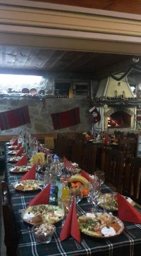 a long table with plates of food on it at Guest House Todorini kashti in Koprivshtitsa