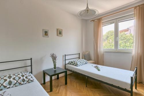 1 dormitorio con 2 camas y ventana en Apartments Veruda Porat, en Pula