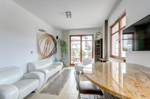 sala de estar con muebles blancos y mesa de mármol en Dom & House - Apartamenty Neptun Park, en Gdansk